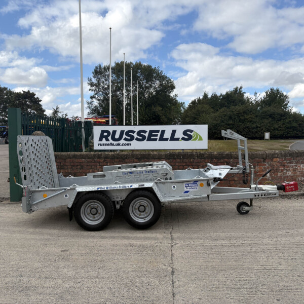 Trailer sits in an industrial yard beneath a Russell's sign, with additional equipment and blue sky above.