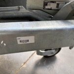 Close-up of a rugged metal frame with a barcode label reading GX106 and other etched markings nearby.