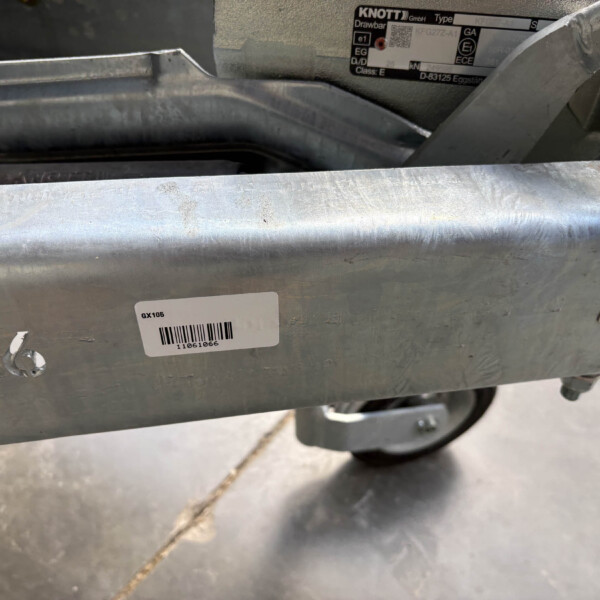 Close-up of a rugged metal frame with a barcode label reading GX106 and other etched markings nearby.