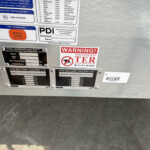 Close-up of a trailer’s rear exterior with warning and information stickers, including 'WARNING! REGISTERED WITH TER'