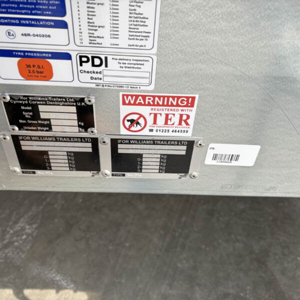Close-up of a trailer’s rear exterior with warning and information stickers, including 'WARNING! REGISTERED WITH TER'