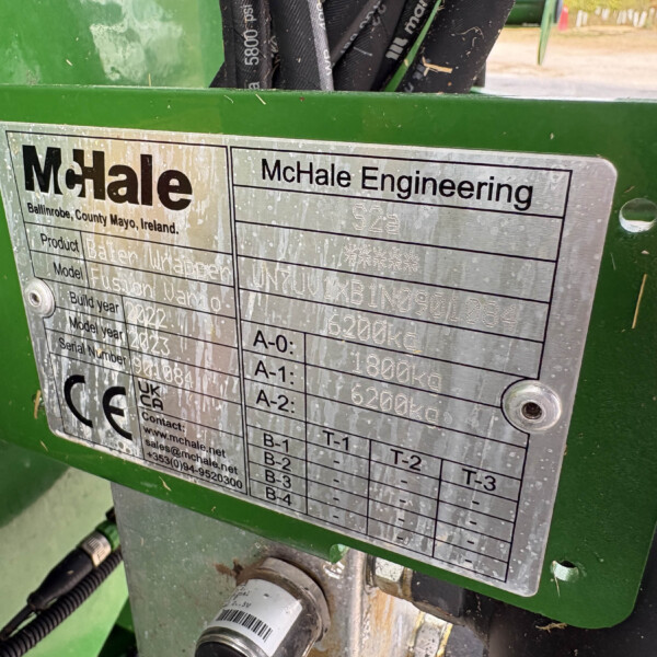 Close-up of a silver nameplate on green machinery showing 'McHale Engineering' and location 'Ballinrobe, County Mayo, Ireland' with model/serial fields visible.