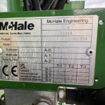 Metal identification plate on a green machine showing 'McHale Engineering' and location, with model and serial data visible (informational label).