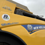 Close-up of a yellow construction machine showing the 'Twin Rotor' label and New Holland branding on the side.