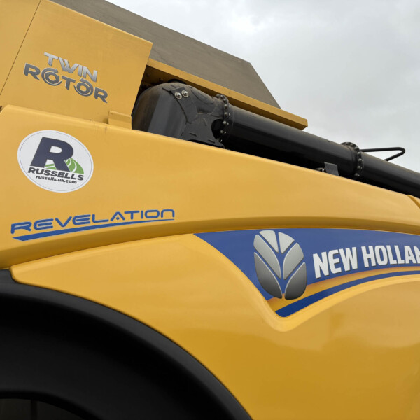 Close-up of a yellow construction machine showing the 'Twin Rotor' label and New Holland branding on the side.