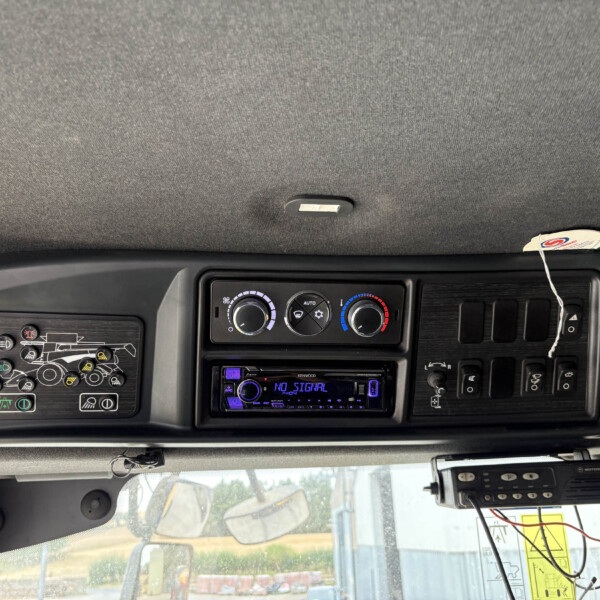 Dashboard panel of a vehicle with climate control dials, a Kenwood stereo, and various switches visible on the center console