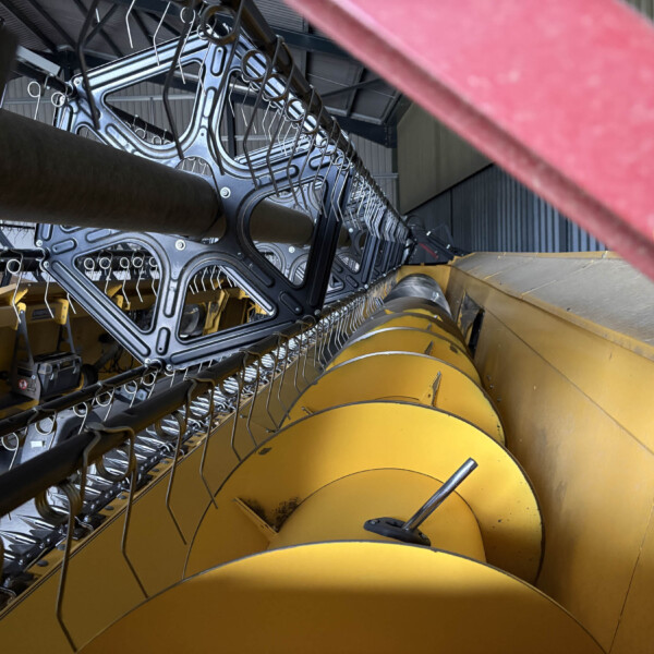 Industrial machinery with metal frames and yellow components, viewed from a tilted angle in a workshop setting