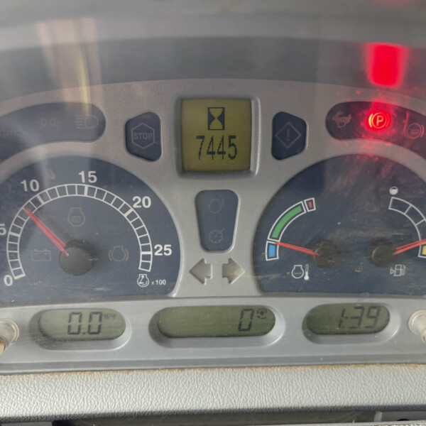 Close-up of a vehicle instrument cluster with a central yellow display and warning icons, showing a numerical readout in the middle.