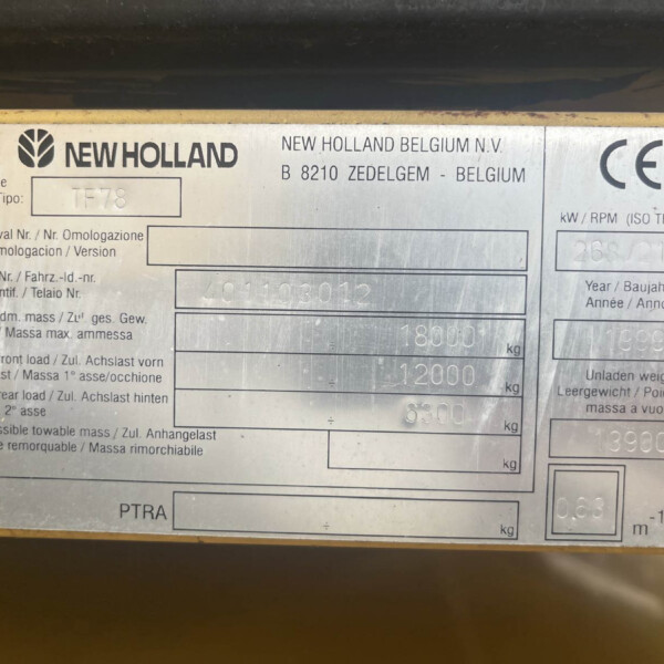 Metal identification plate on a yellow surface showing the New Holland logo and model TF78 with weight fields.