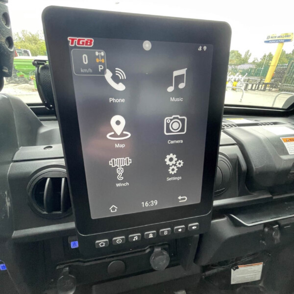 Vehicle infotainment touchscreen displaying apps (Phone, Music, Map, Camera, Settings) inside a car cabin.