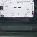 Vehicle dashboard display showing idle RPM around 1300, time 17:49, gear in Neutral, fuel gauge and range around 890 km, outside temp 22°C.