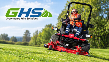 Worker in an orange safety vest operates a red ride-on mower on a sunny green field; GHS Groundcare Hire Solutions logo appears in the upper-left corner.