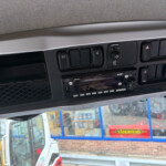 Close-up of vehicle dashboard switches and hazard light button in a truck cab.