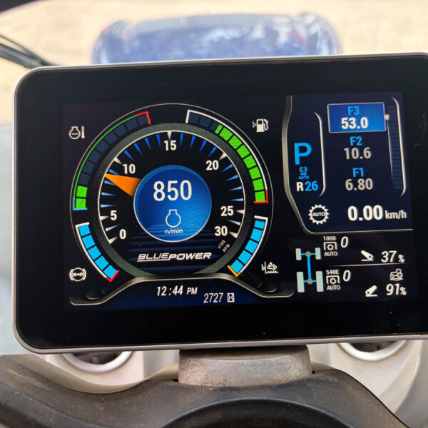 Close-up of a car's digital instrument cluster: circular tachometer showing 850, green/yellow/red indicators, and a parked (P) indicator with fuel and other readouts on the right side.