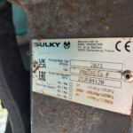 Metal label on a rusted machine showing Sulky brand and CE symbol, with model and year 2023 details.