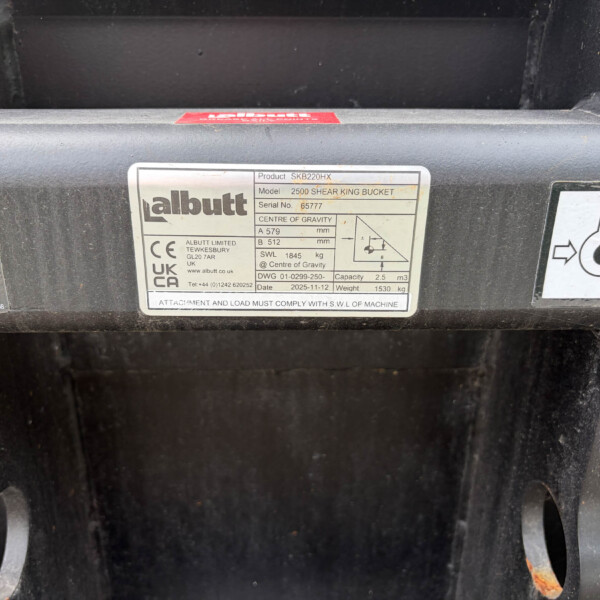 Close-up of a metal data plate on a black frame, listing product SKB220HX, model 2500 Shear King Bucket, serial 65777 and 2.5 m³ capacity (Albutt).
