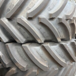 Close-up of stacked heavy-duty tractor tires with deep zigzag treads outside.