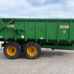 Green trailer with yellow rims sits on a paved lot, showing Easterby Trailers labels and a small UK flag sticker on the side as a clear, informative view.