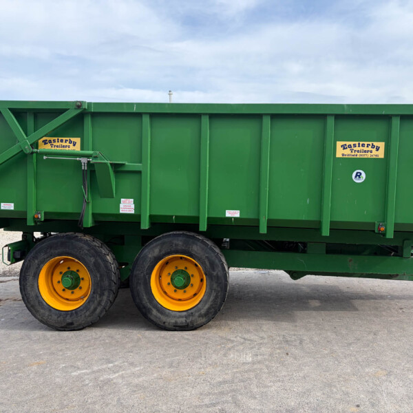 Green trailer with yellow rims sits on a paved lot, showing Easterby Trailers labels and a small UK flag sticker on the side as a clear, informative view.
