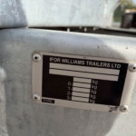 Close-up of a trailer identification plate on a gray metal frame, showing the company name IFOR WILLIAMS TRAILERS LTD and weight specifications.