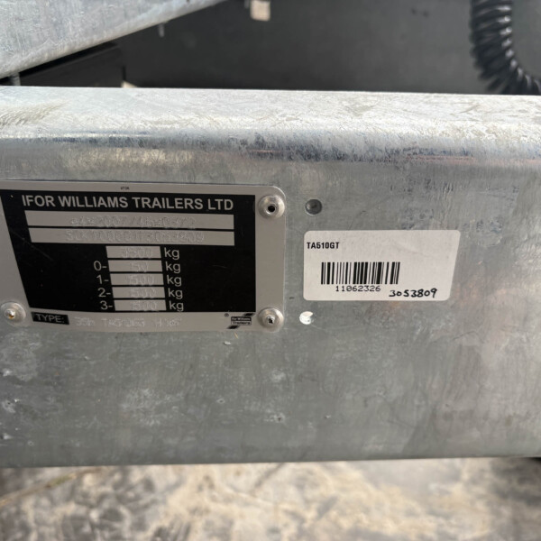 Close-up of a galvanized trailer frame with the Ifor Williams Trailers plate, showing model numbers, serial/barcode, and weight rating