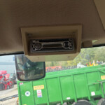 Overhead beige car stereo mounted in a vehicle cab, with a Panasonic radio unit built into the ceiling panel.