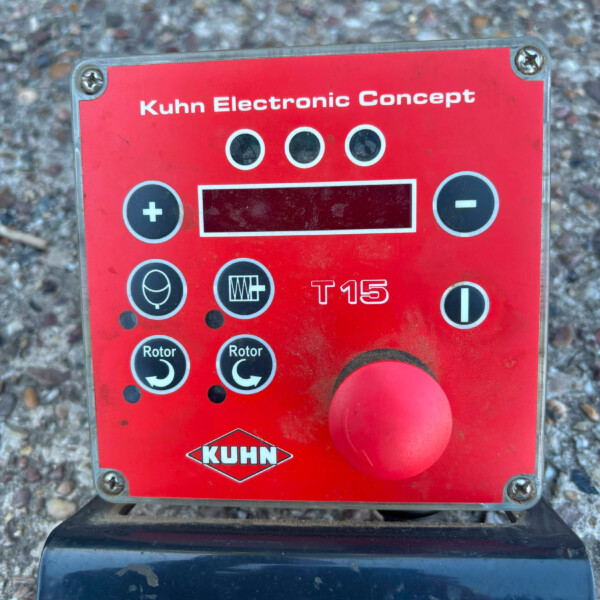 Red KUHN Electronic Concept control panel with a large red joystick and multiple circular indicators/dials on a dirt surface, likely agricultural equipment.