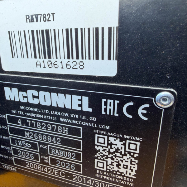 Close-up of a black metal plate with a white barcode label, a QR code, and the McConnell brand name visible on a machine panel.