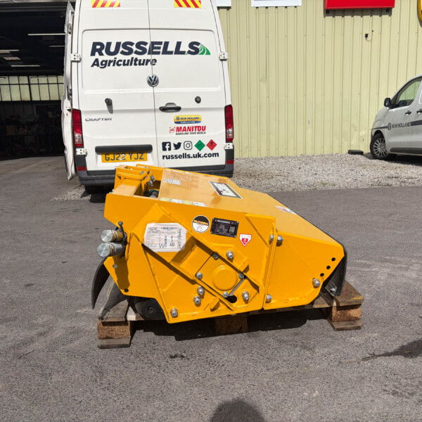 Rear view of Russell's Agriculture white van in a storage yard with another branded van nearby and a yellow industrial machine in the foreground.