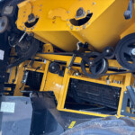 Close-up of yellow industrial machine internals with gears, belts, and pulleys