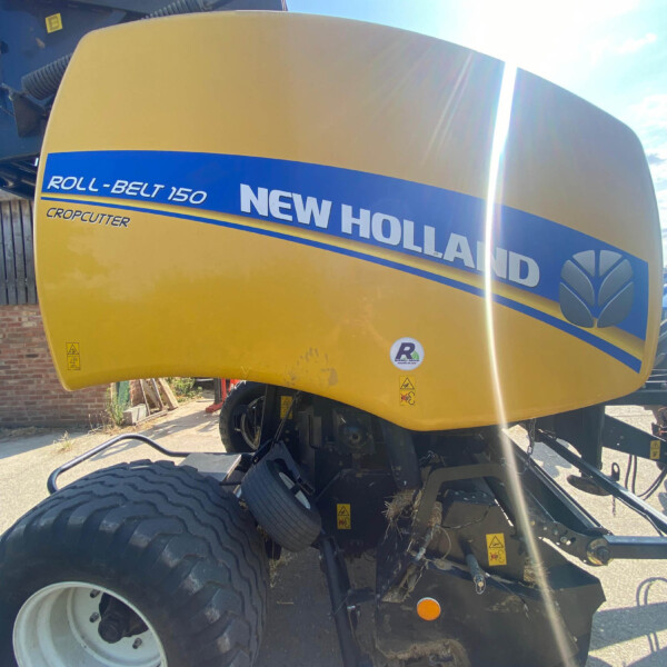 Front view of a yellow New Holland Roll-Belt 150 combine header with a blue stripe and logo, large tire visible at the bottom.