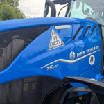 Close-up of a blue New Holland tractor cabin with 'Dynamic Command' badge and model label T5.140 on the hood.