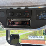 DashboardControls: three climate knobs and a Kenwood stereo, with a blue tractor graphic on the right panel and a 'RUSSELLS' sign visible outside the window.