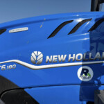 Close-up of a blue New Holland tractor hood with ventilation grilles and the Dynamic Command badge visible