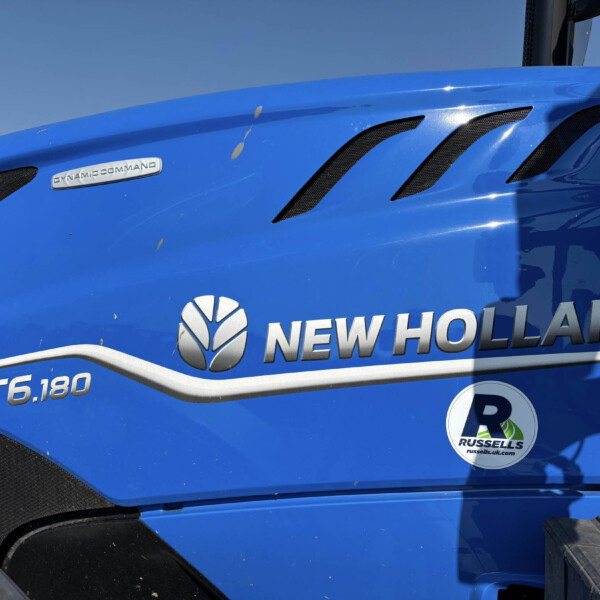 Close-up of a blue New Holland tractor hood with ventilation grilles and the Dynamic Command badge visible