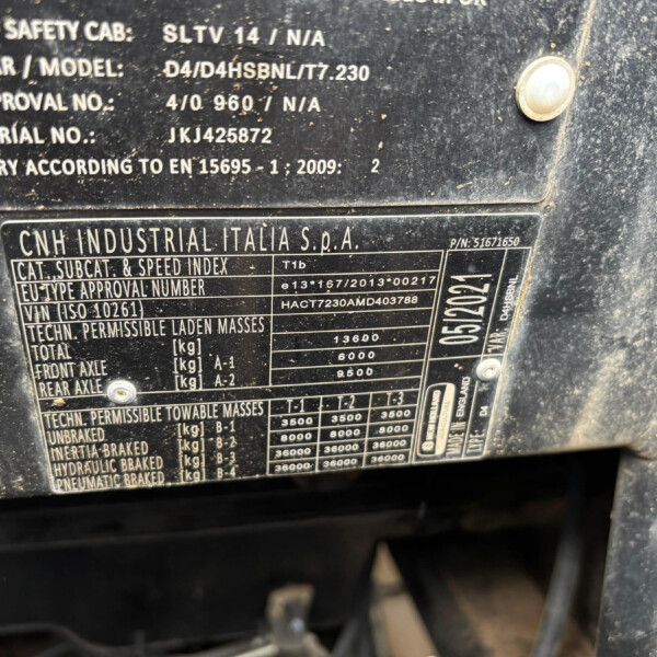 Close-up of a dusty vehicle identification plate showing CNH Industrial Italia S.p.A. and technical specs like model, approval numbers, and masses.