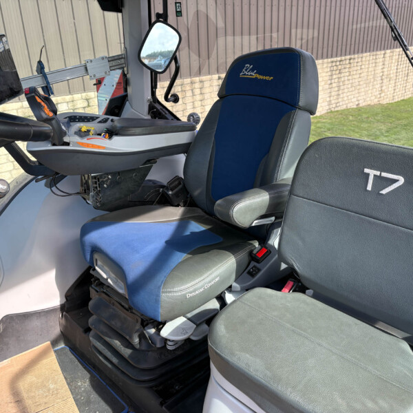 Interior of a vehicle cabin with a blue-seat labeled 'Blue Power', control panel, joystick, and a mounted tablet on the left side.