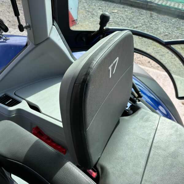 Interior of a vehicle cabin with gray seats, a red seat belt buckle, and gravel ground visible outside through an open door. Afterword: confirm