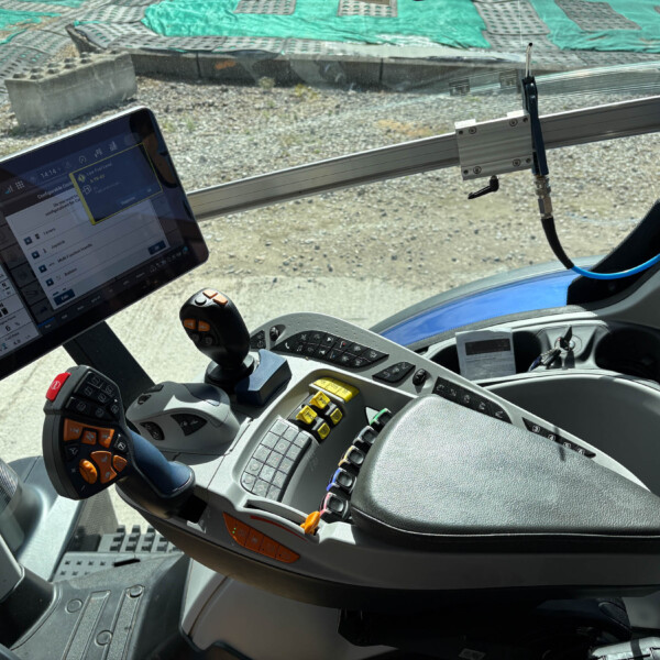 Cabin interior with a touchscreen tablet displaying controls, a joystick with orange buttons, and a panel of switches.",