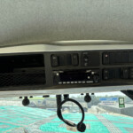 Overhead vehicle dashboard with a row of black switches and a central display screen in a truck cab.