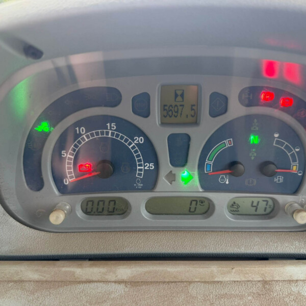Vehicle instrument cluster with multiple illuminated warning lights and a central digital readout showing 5697.5.