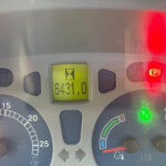 Close-up of a car instrument cluster with several warning lights lit (red parking brake indicator on the right) and an odometer reading 6,431.0 miles in the center screen.