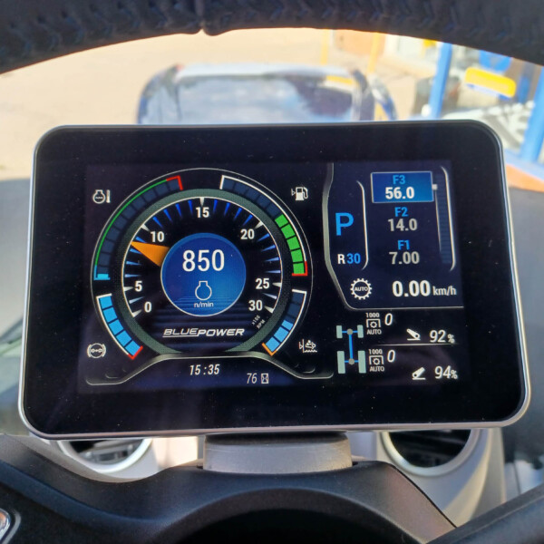 Close-up of a digital vehicle dashboard showing tachometer, blue power gauge, and gear indicator (P).