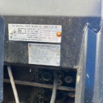 Metal data plate on a dusty truck chassis reading 'CNH Industrial Europe Holding S.A.' Made in the UK.