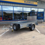 Exterior of Russells service center with blue-framed windows; a silver trailer is parked in the lot.