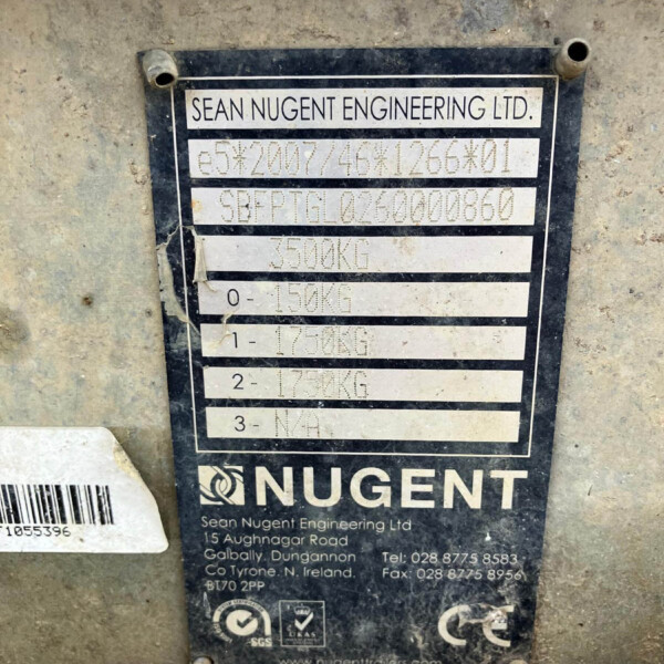 Metal identification plate on a dirty concrete surface reading Sean Nugent Engineering Ltd with weight and serial data