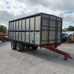 Large metal-sided freight trailer on a wheeled trailer in an industrial yard