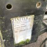 Close-up of a dirty black mower frame with a weathered Hayter label visible