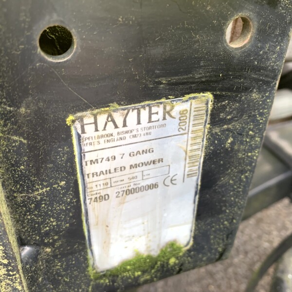 Close-up of a dirty black mower frame with a weathered Hayter label visible