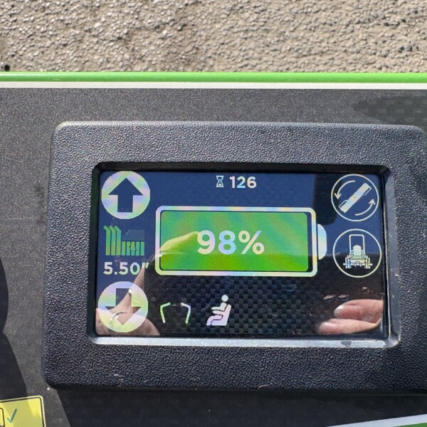 Close-up of a handheld device screen in a textured black case showing 98% on a green bar with icons (arrow up, book, circular controls) above a lime-green accent bar.